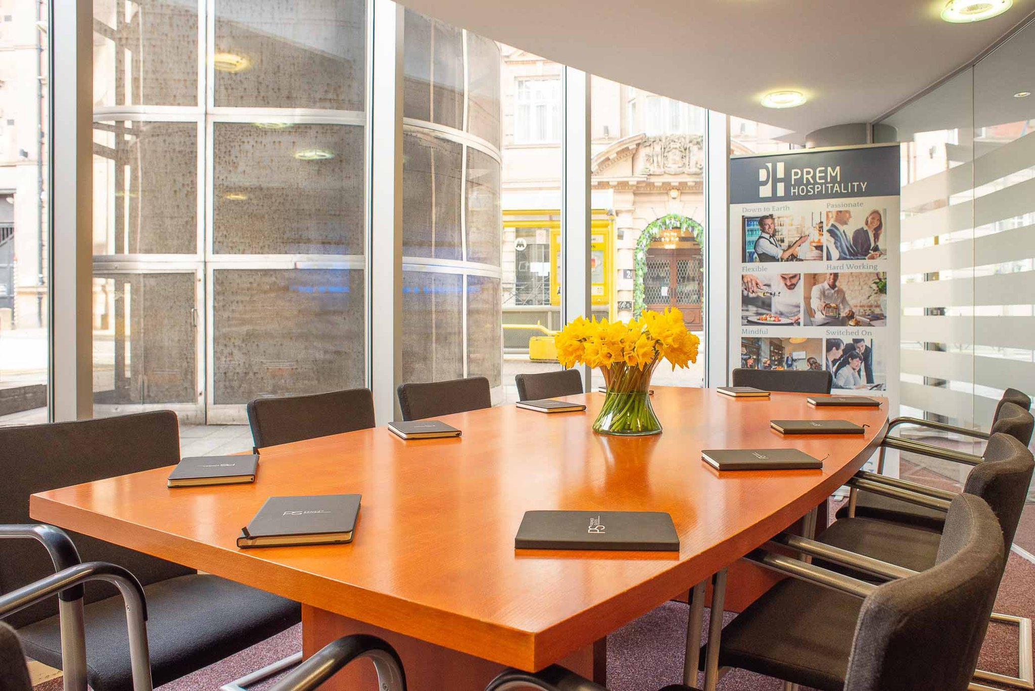 Meeting_room_with_large_wooden_table_and_black_chairs_ove_S