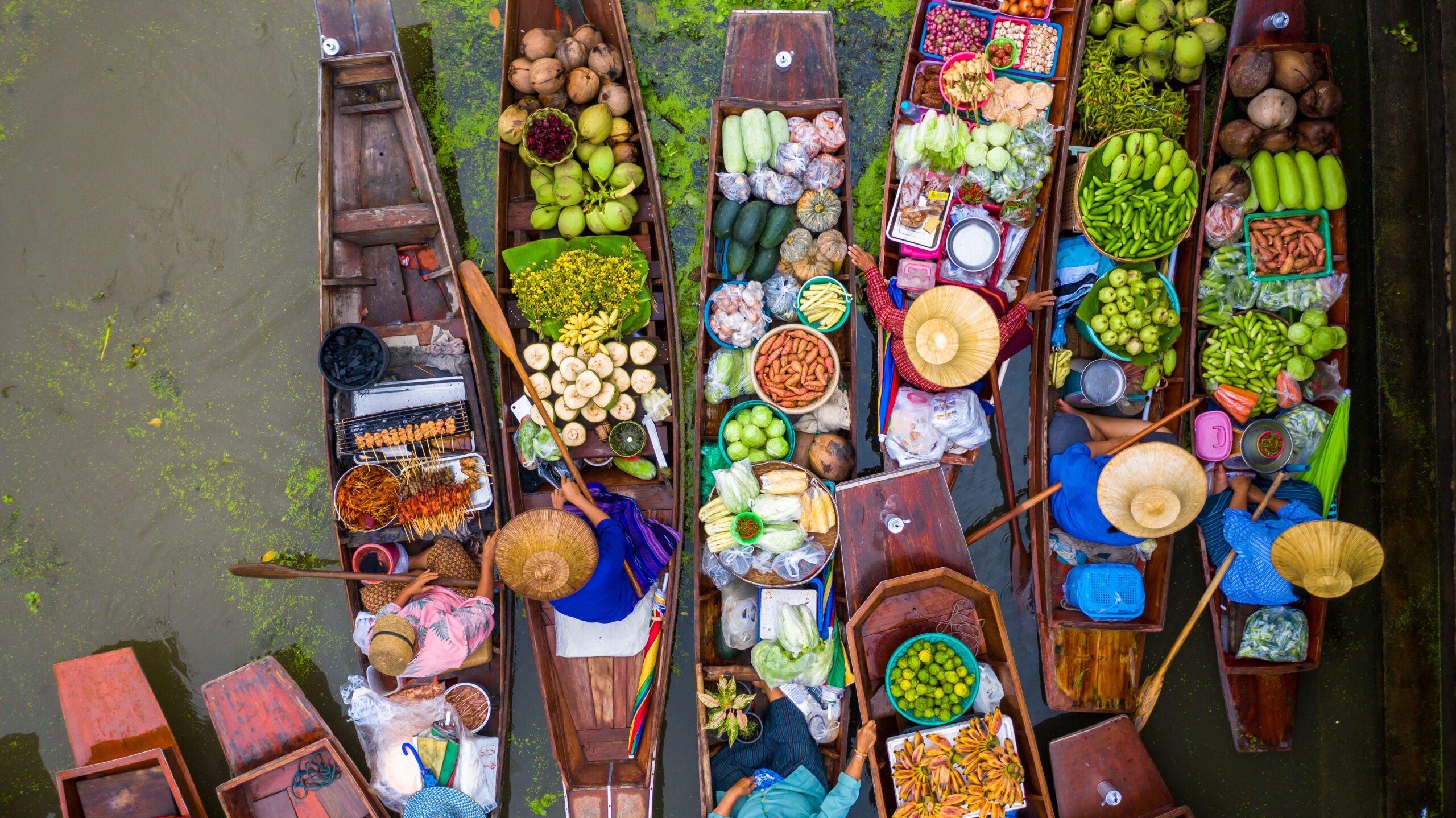 Aerial view famous floating market in Thailand, Damnoen Saduak floating market, Farmer go to sell organic products, fruits, vegetables and Thai cuisine, Tourists visiting by boat, Ratchaburi, Thailand