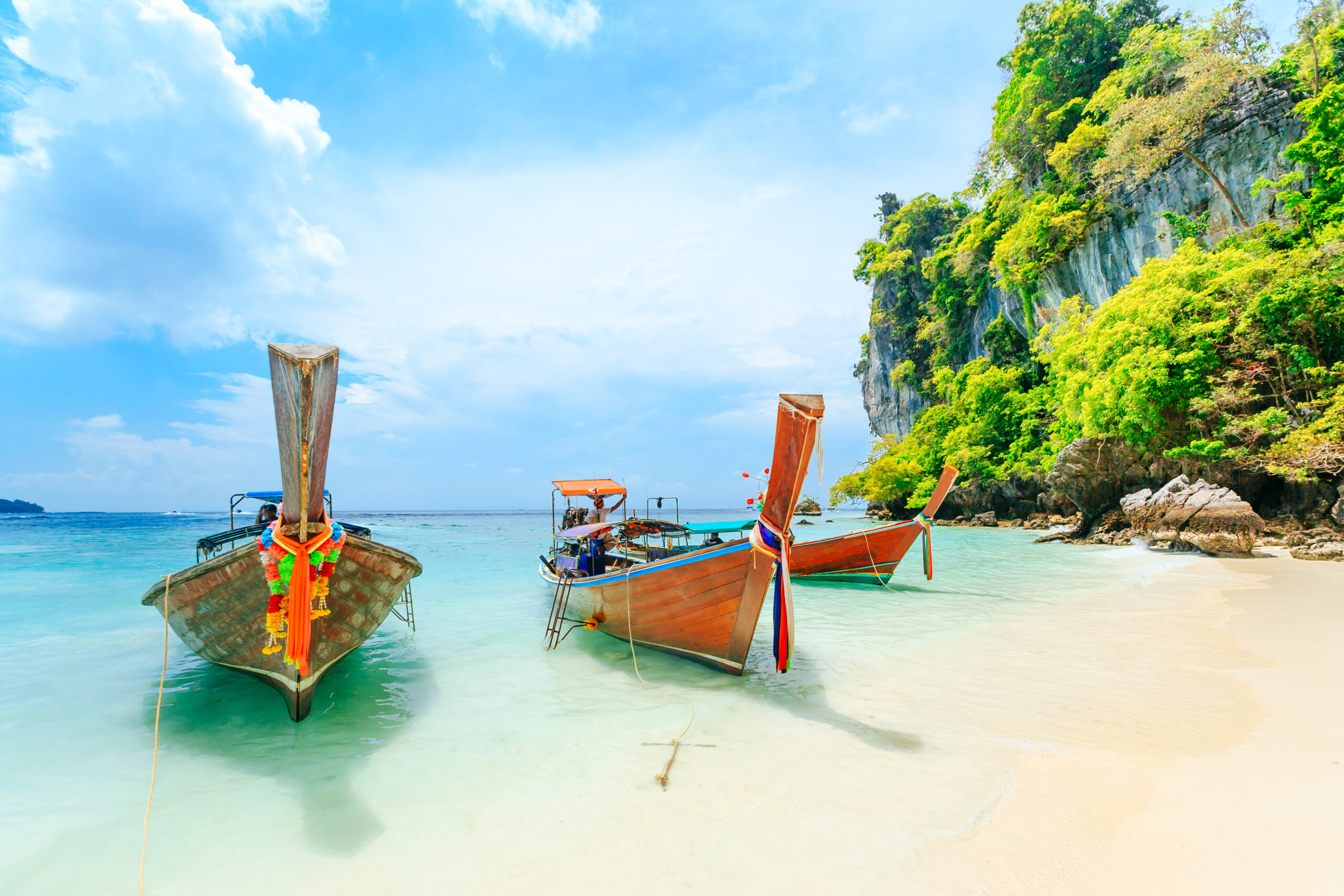 Longtale boat on the white beach at Phuket, Thailand. Phuket is